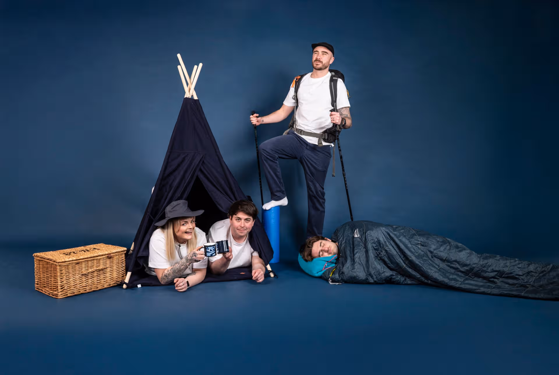 Team members camping indoors with tent, backpack, and sleeping bag, illustrating a creative team approach at Salience.