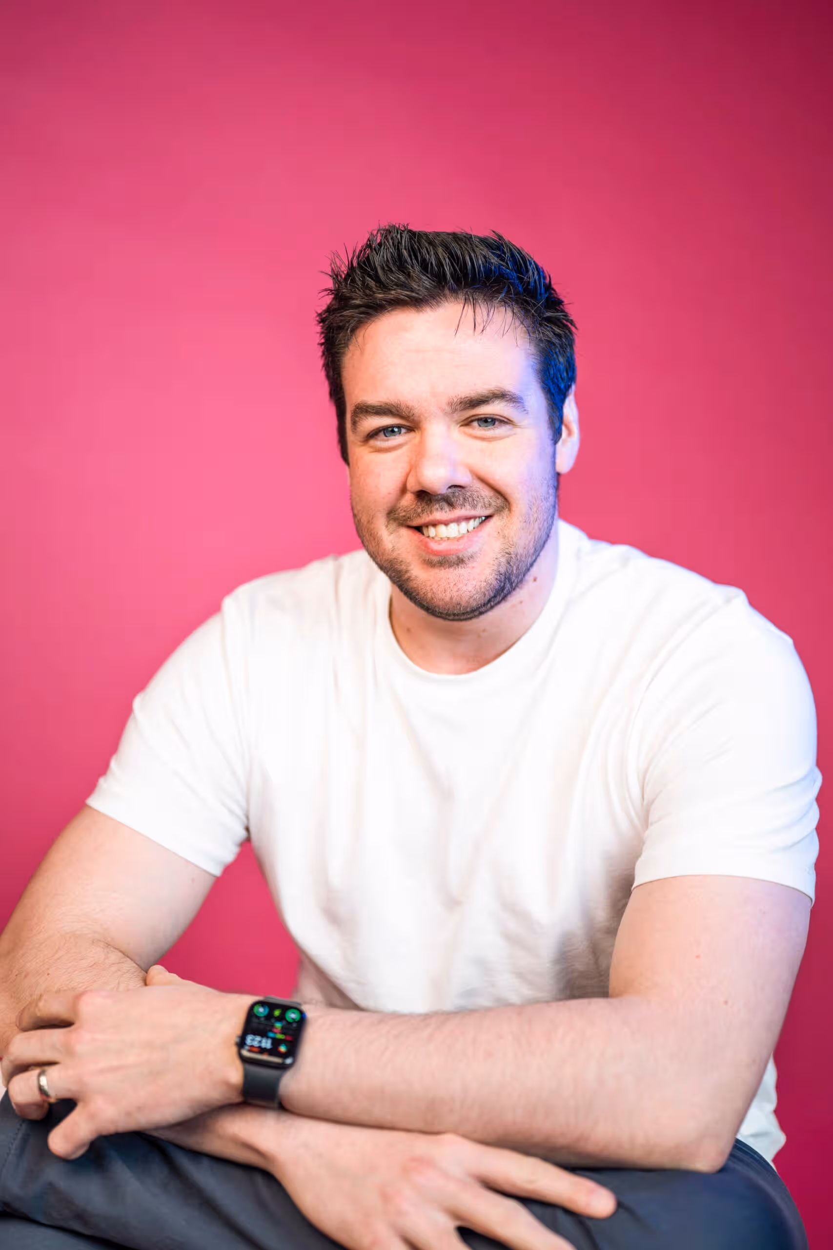 Marketing professional headshot smiling against vibrant pink background