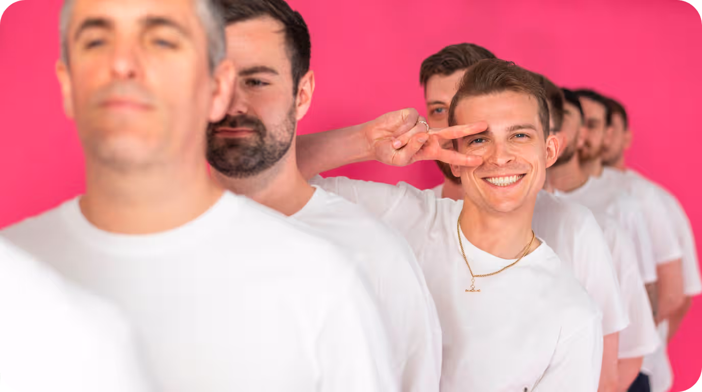 Men in white shirts lined up against a pink background, showcasing team unity at a search marketing agency.