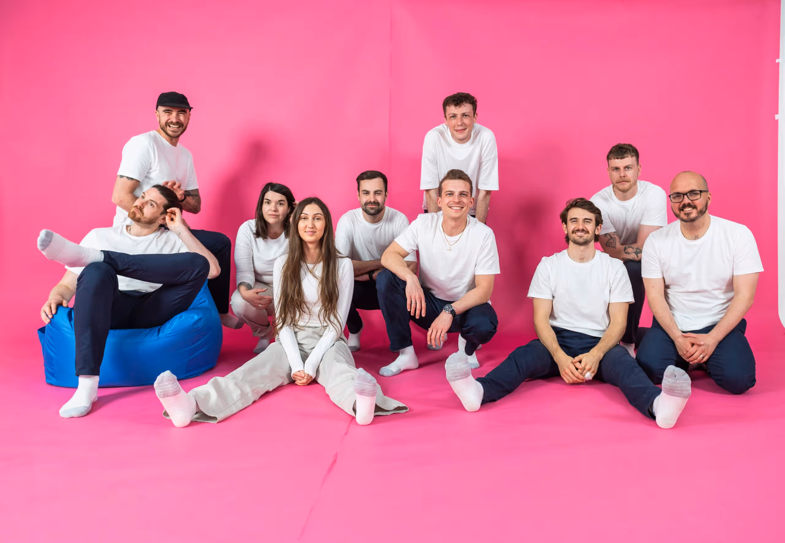 Team members of Salience marketing agency posing on a pink background in casual attire.