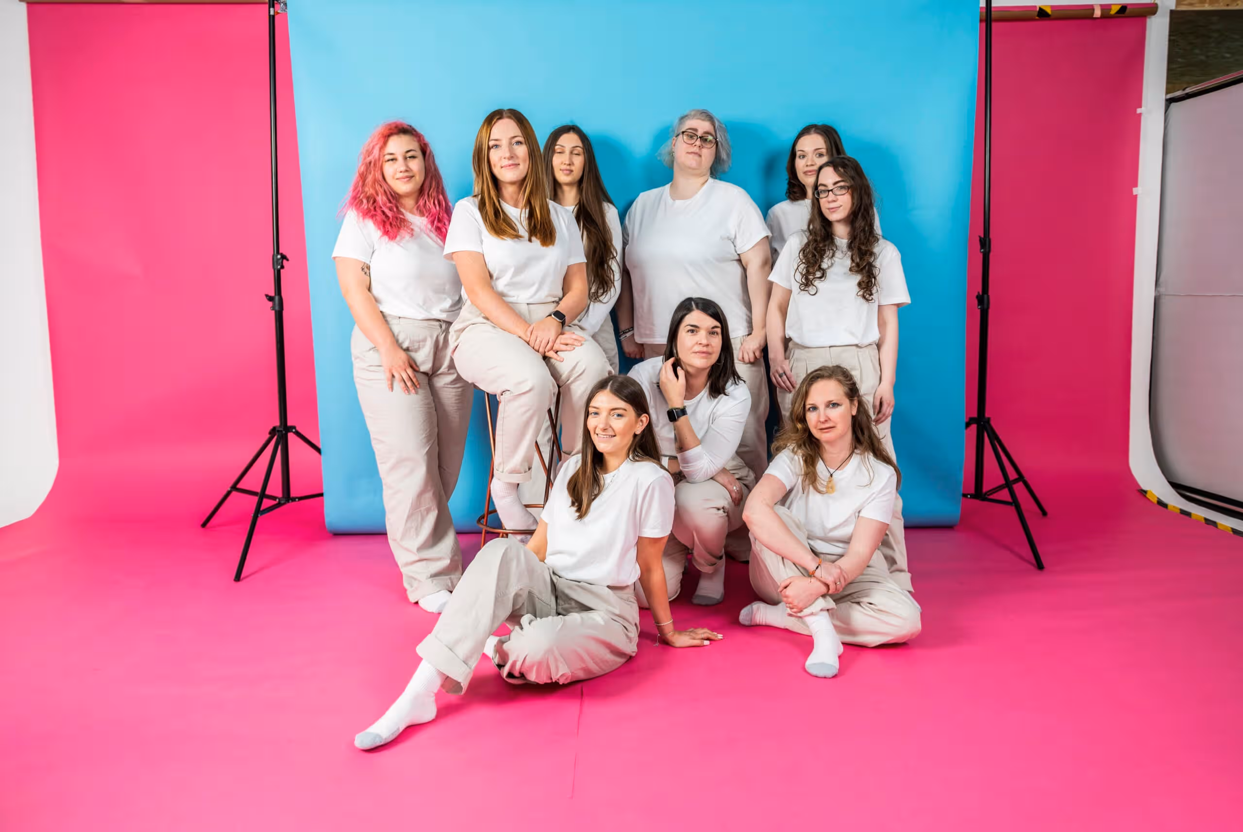 Team members posing for Salience marketing agency's "About Us" section on vibrant pink and blue background.