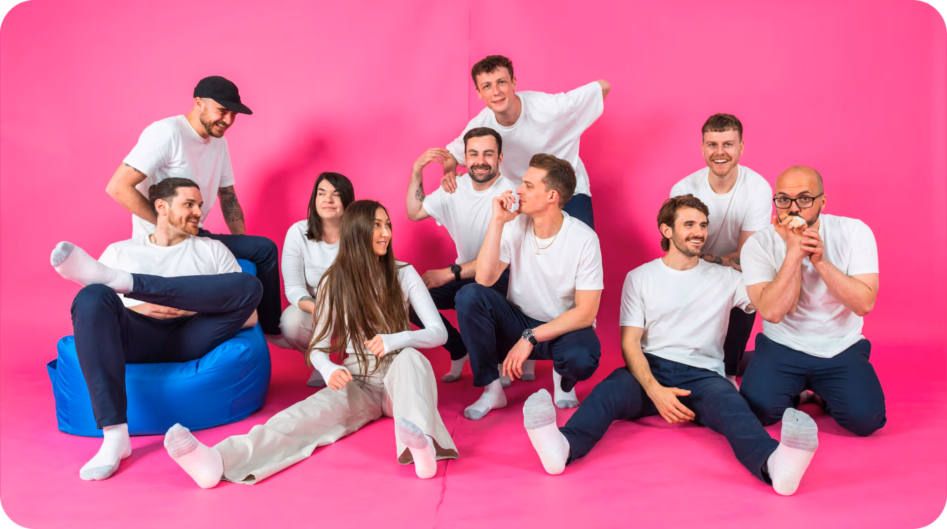 Team members of Salience marketing agency posing in coordinated white outfits against a pink backdrop.